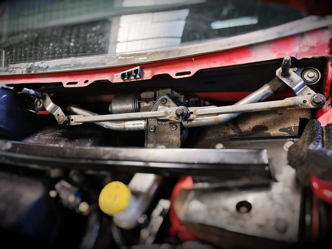 Windshield wiper linkage directly in front of the windshield (FIAT Freemont)