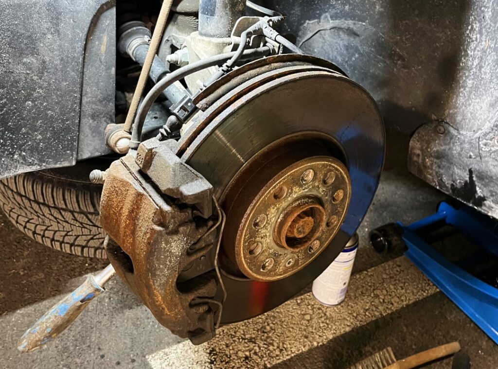 Samochód podniesiony, koło zdemontowane Przygotowanie: Podnieś samochód, zdemontuj koło