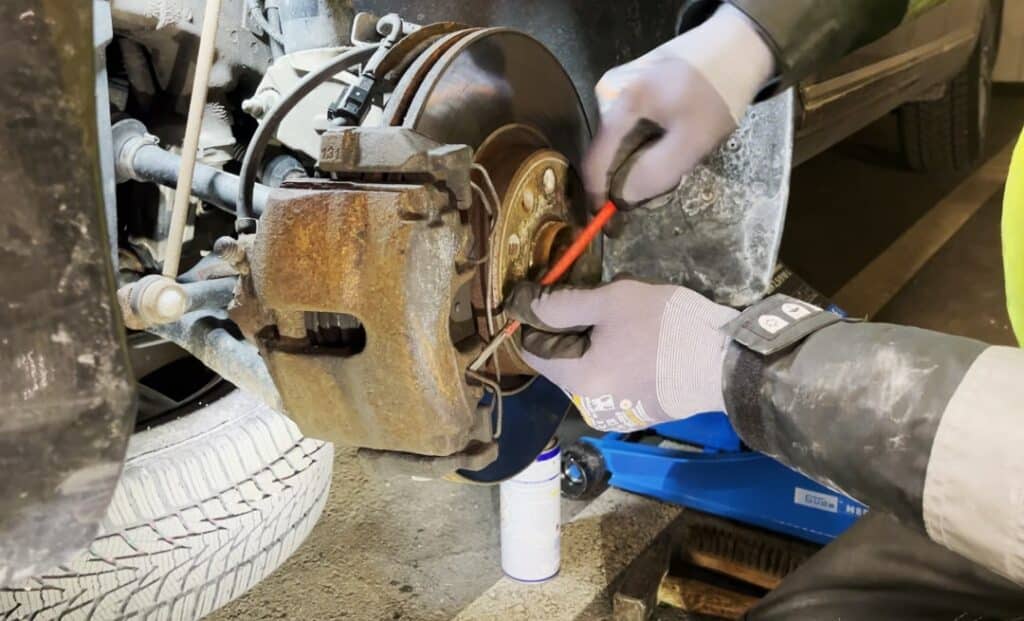 Zwolnij sprężynowy zaczep zacisku hamulcowego Poluzuj sprężynowy zaczep zacisku za pomocą śrubokręta lub łomu