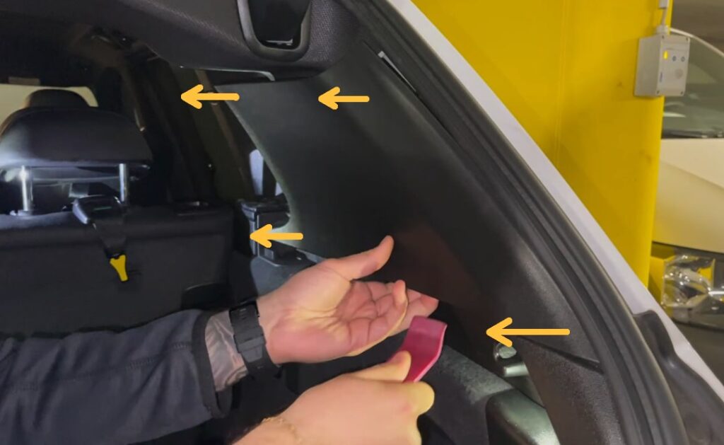 Desengancha el revestimiento del pilar D Suelta la cubierta de plástico del pilar D en el maletero